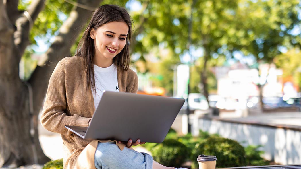 Frau im Park mit Laptop