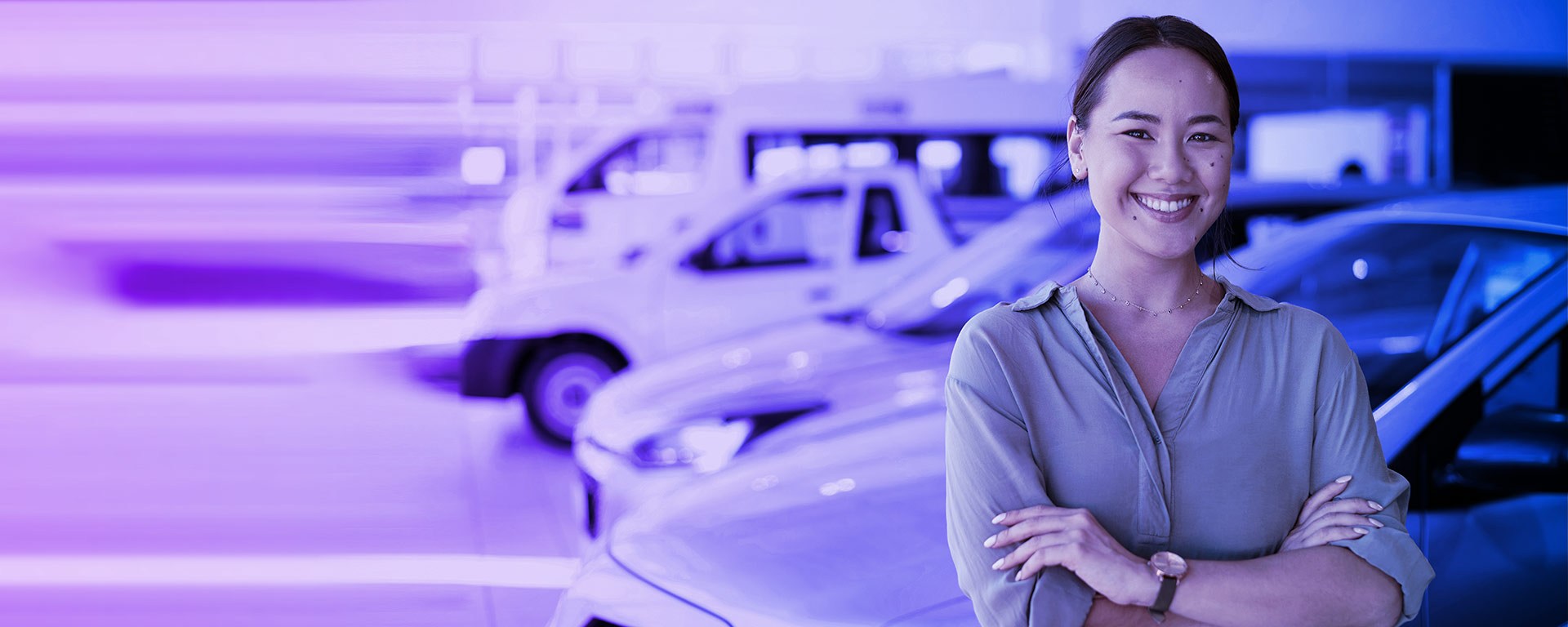 Woman with folded arms with cars in the background