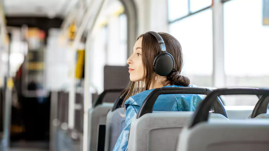 Frau mit Kopfhörern im Bus